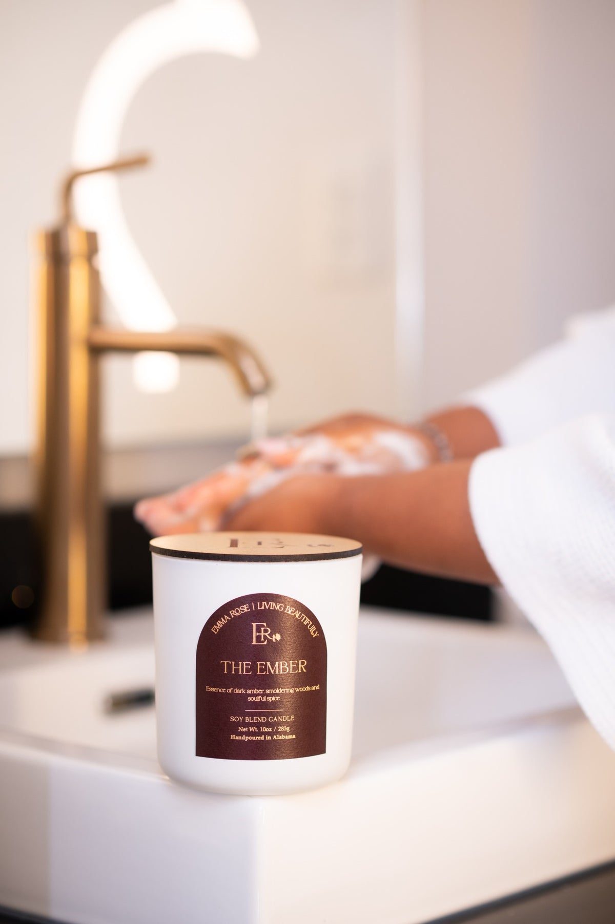 The Ember dark amber candle styled in a luxury spa setting