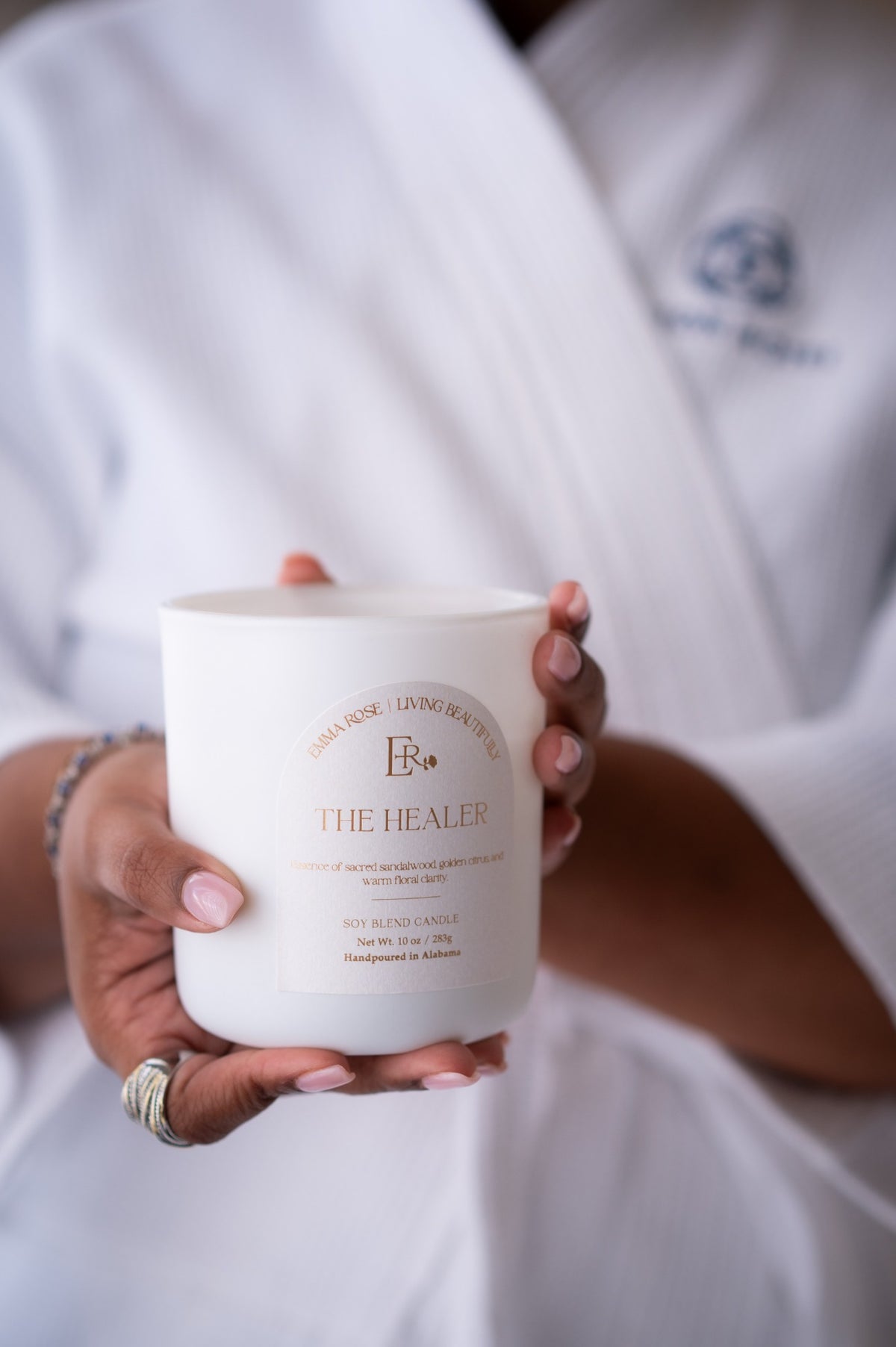 The Healer citrus floral candle held in a calming spa setting